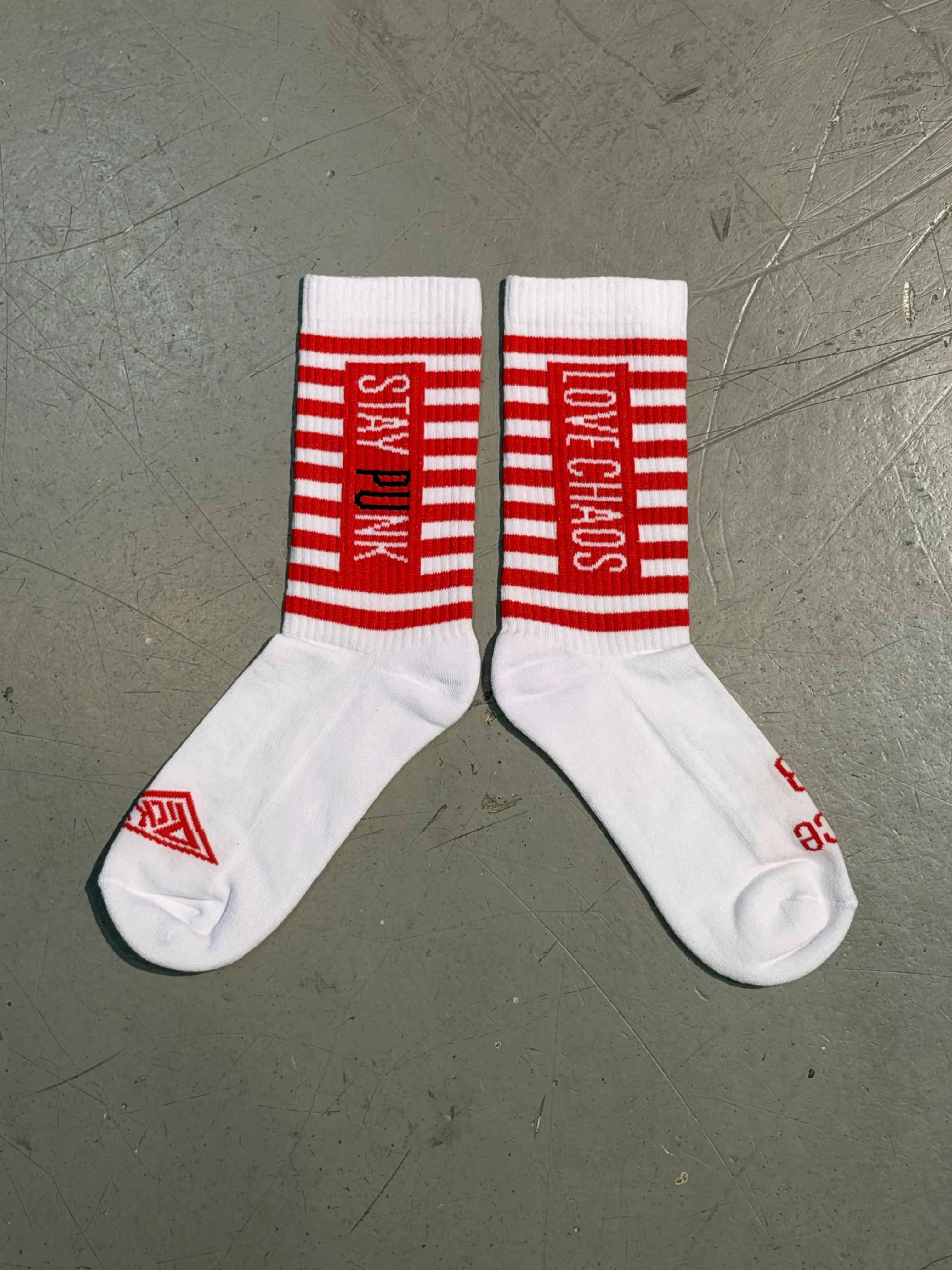 PICK UP Striped Socks Weiß/Rot mit Stay Punk und Love Chaos Schriftzug auf Betonboden